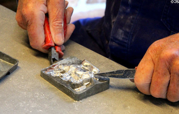 Artisan removing tin figure from mold at National Tin Figure Museum. Ommen, Netherlands.