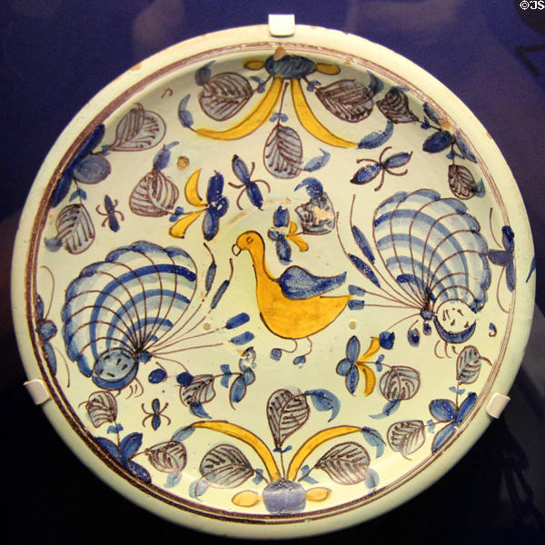 Ceramic charger (c1685) with decoration of bird, butterflies & other flying insects in yellow, blue & purple, made in Brislington close to Bristol, at Bristol Museum & Art Gallery. Bristol, England.