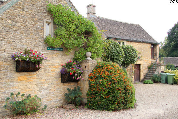 "Home Farmhouse" (c1700) with wall bedecked by flowers & plantings. Upper Slaughter, England.
