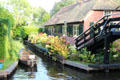 Narrow side canal with boat used for transportation around the town. Giethoorn, Netherlands.