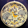 Ceramic charger with decoration of bird, butterflies & other flying insects in yellow, blue & purple, made in Brislington close to Bristol, at Bristol Museum & Art Gallery. Bristol, England.