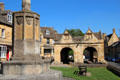 War memorial to men of town who died during WWI with market hall in background on High St. Chipping Campden, England.