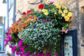 Floral bouquet hanging from wall along High St. Chipping Campden, England.